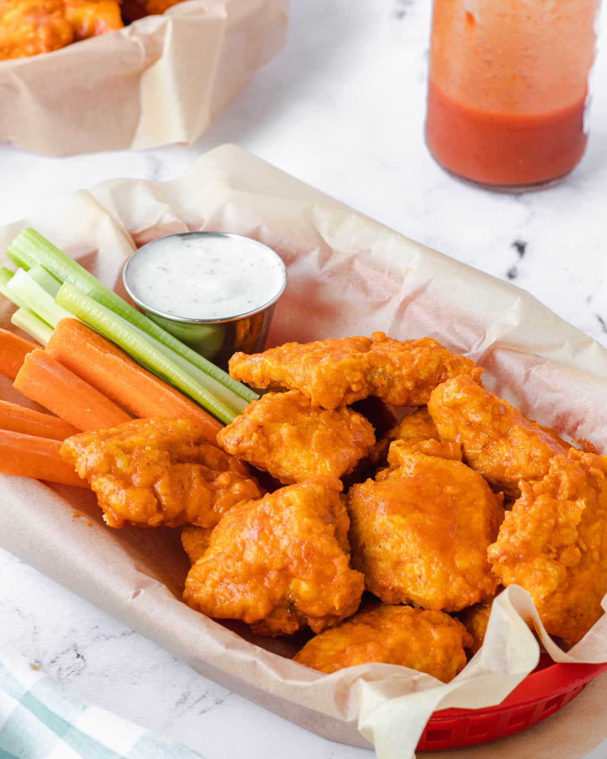 Air fryer boneless chicken wings in a parchment lined basket.