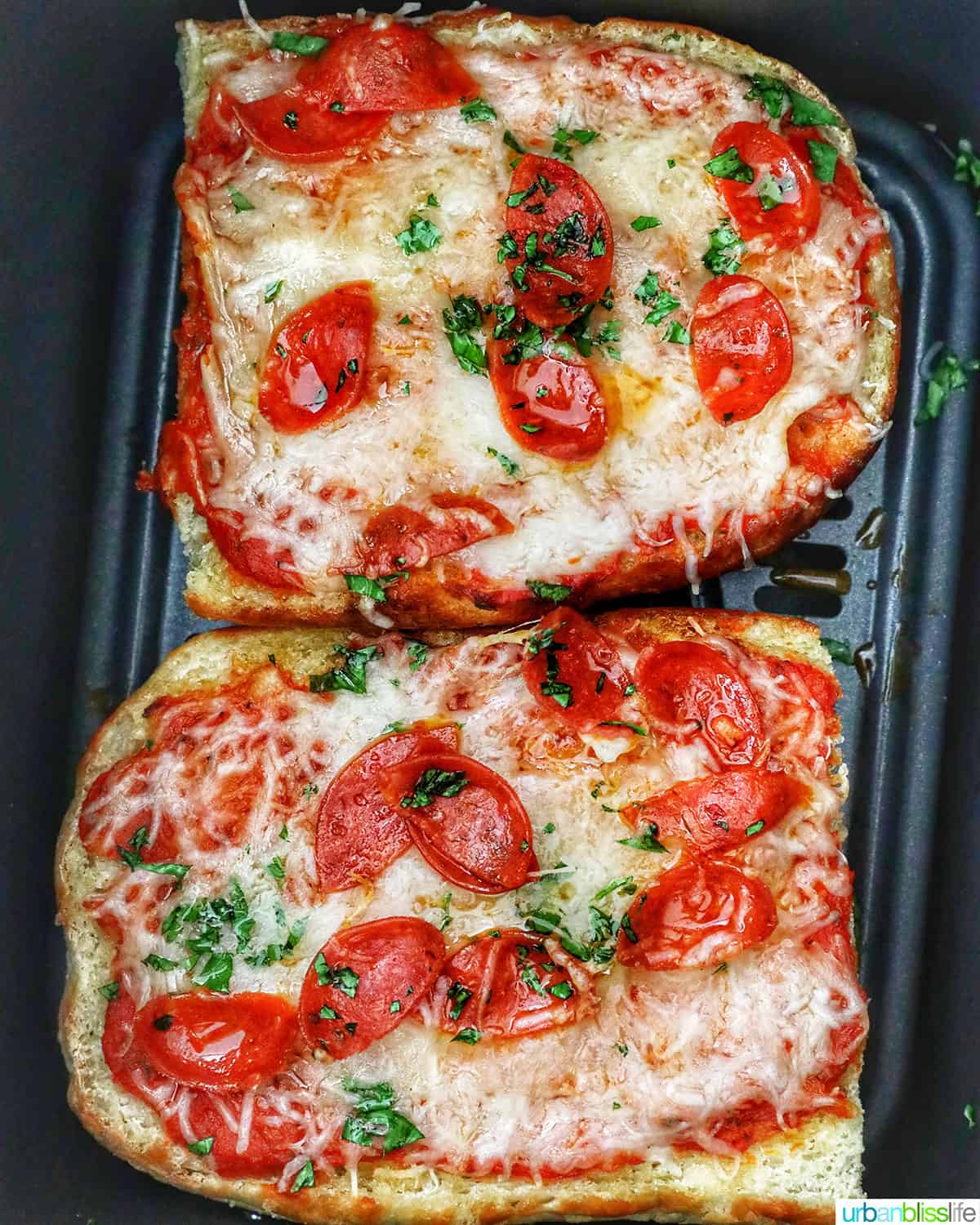 Pepperoni pizza in an air fryer basket.