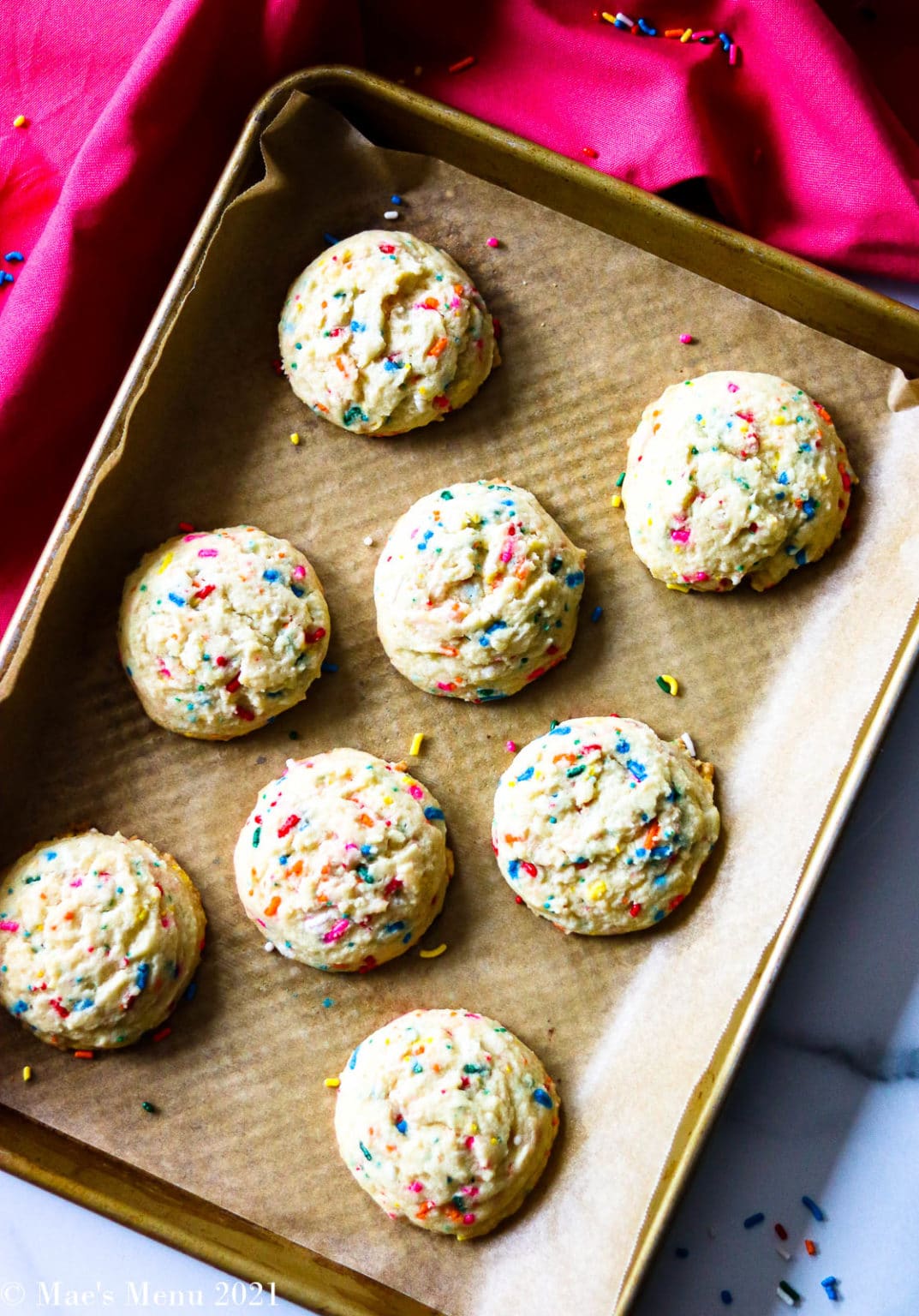 Birthday cake cookies on a parchment lined cookie sheet.