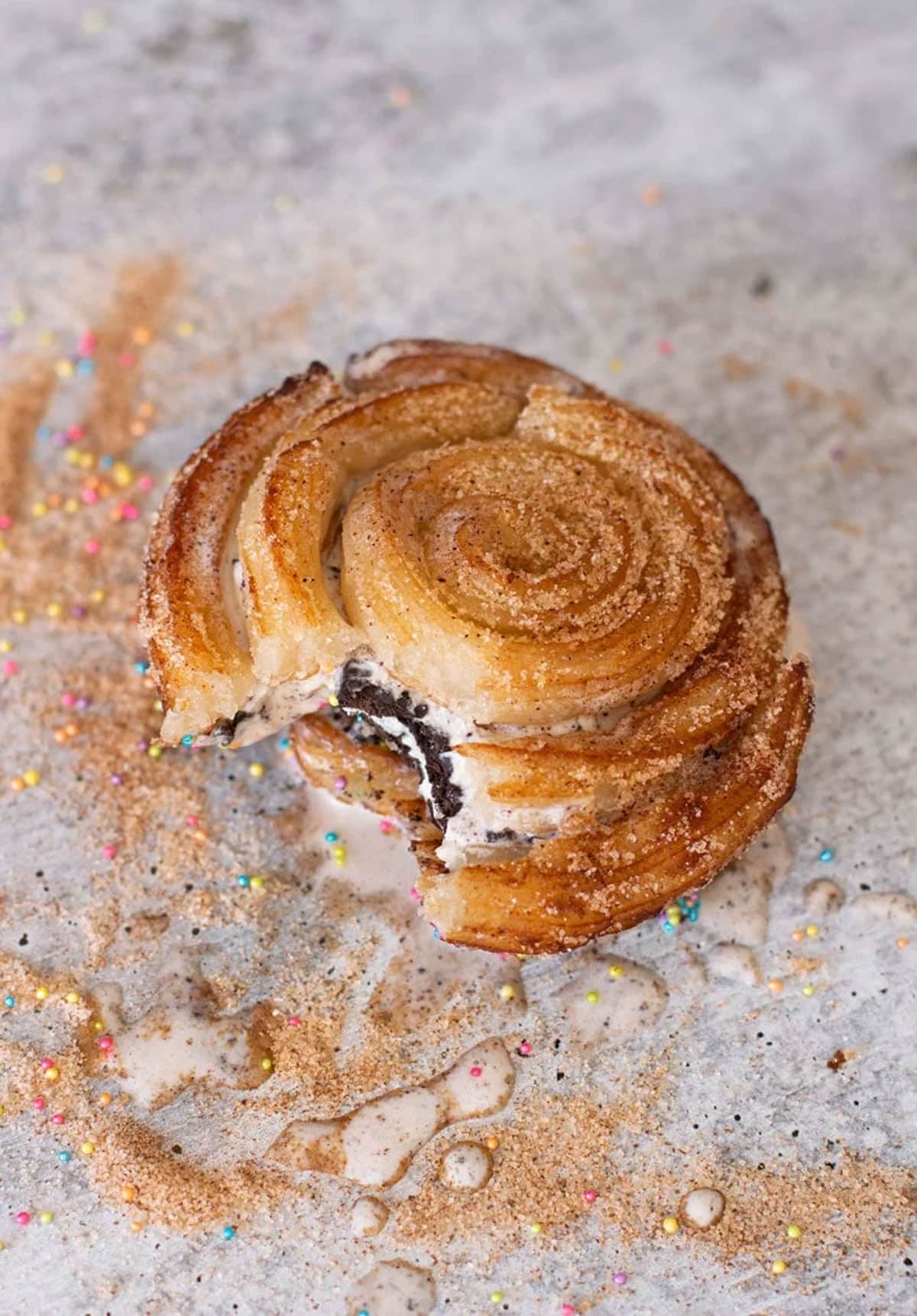 Churro ice cream sandwich on a light colored surface.