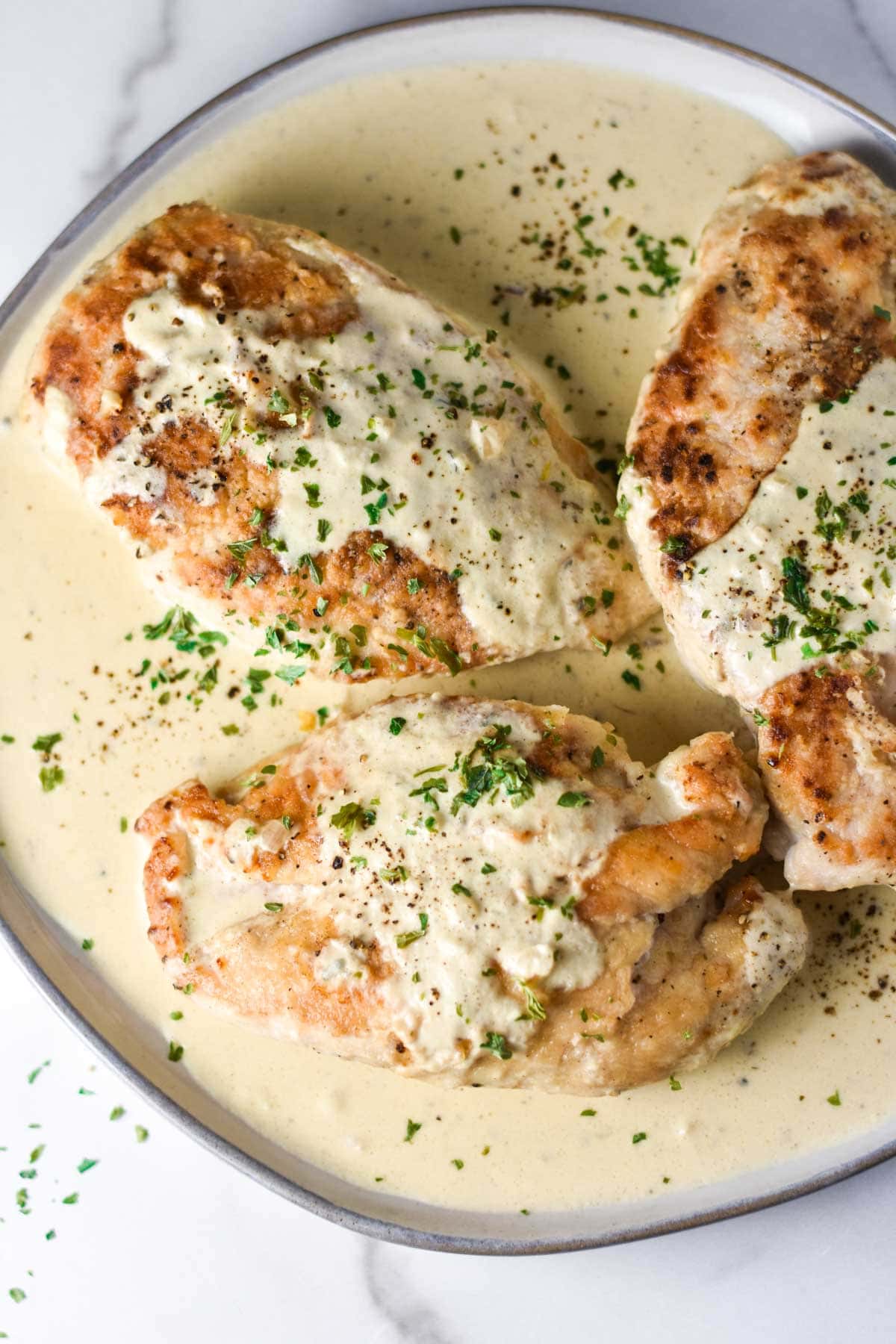 Creamy chicken recipe on a white plate.