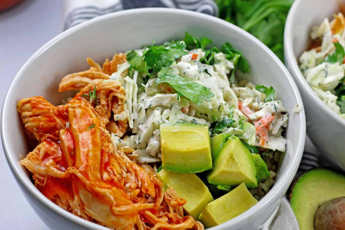 Buffalo chicken rice bowl in white bowls.