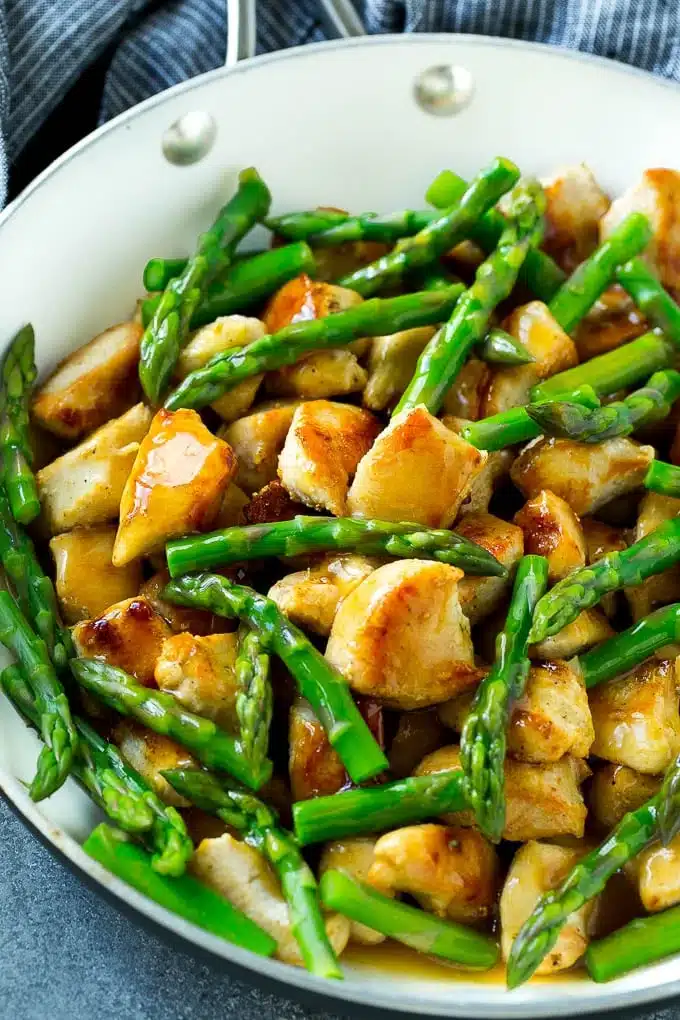 Chicken and asparagus in a skillet.