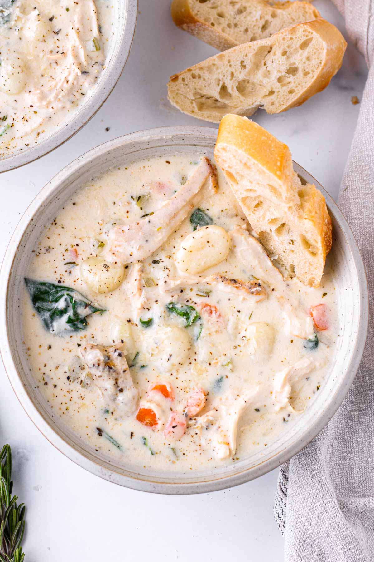 Creamy chicken gnocchi soup in light colored bowl.