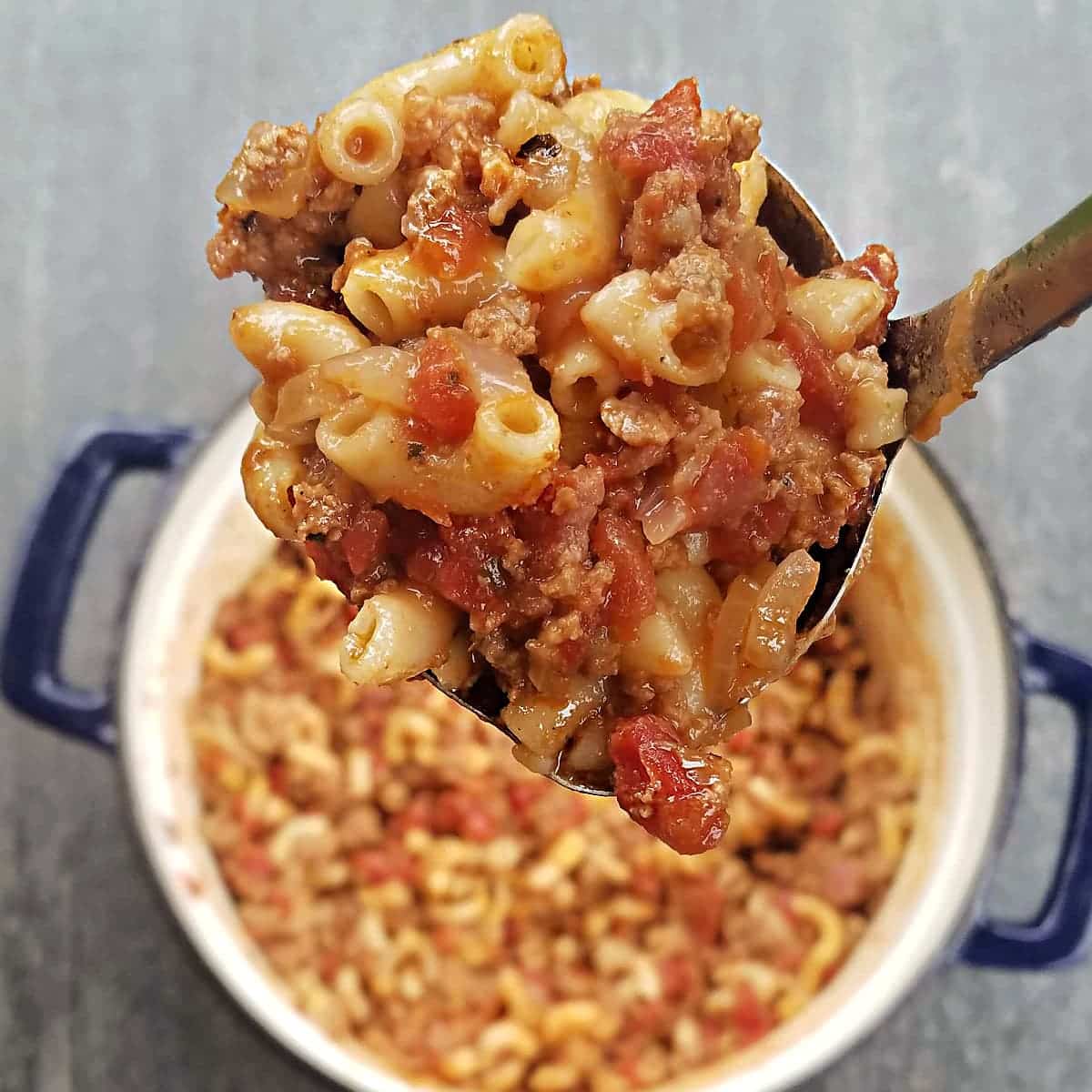 Spoonful of chili mac with more in the Dutch oven.