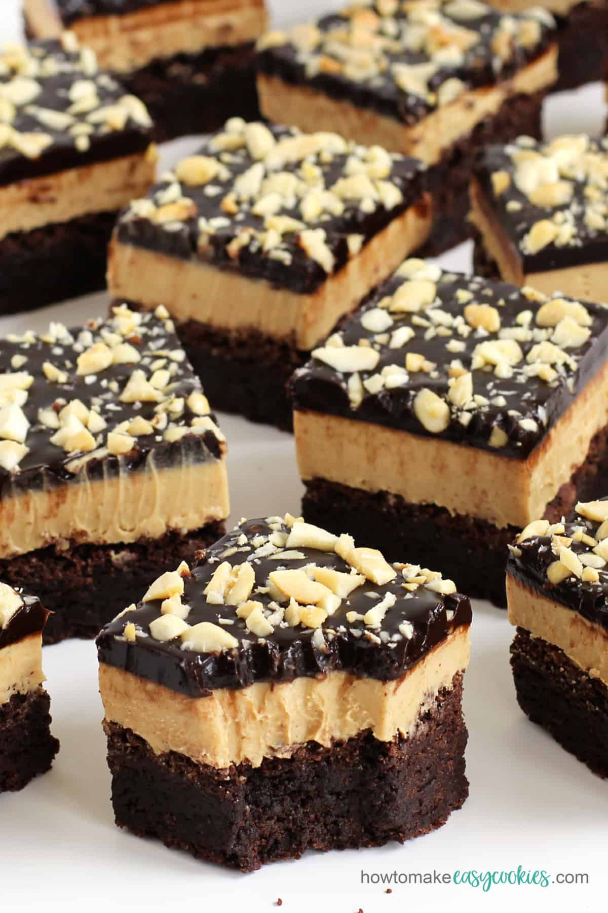 Chocolate peanut butter cookie bars on a white surface.