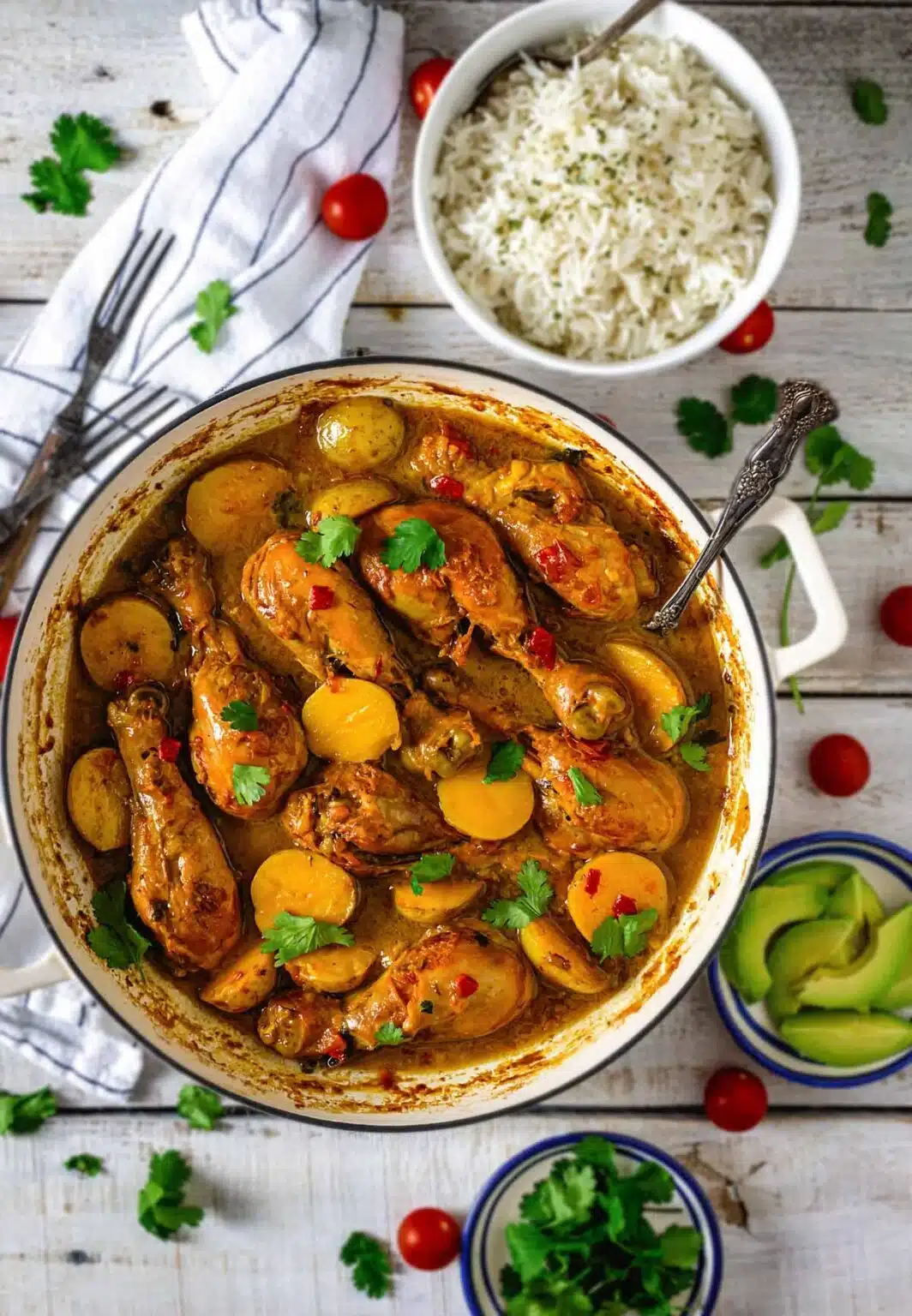 Colombian chicken and potato stew in a Dutch oven with ingredients on the side.