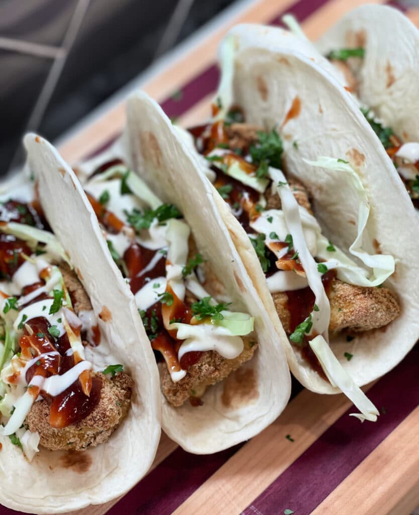Crispy chicken tacos lined up next to one another.