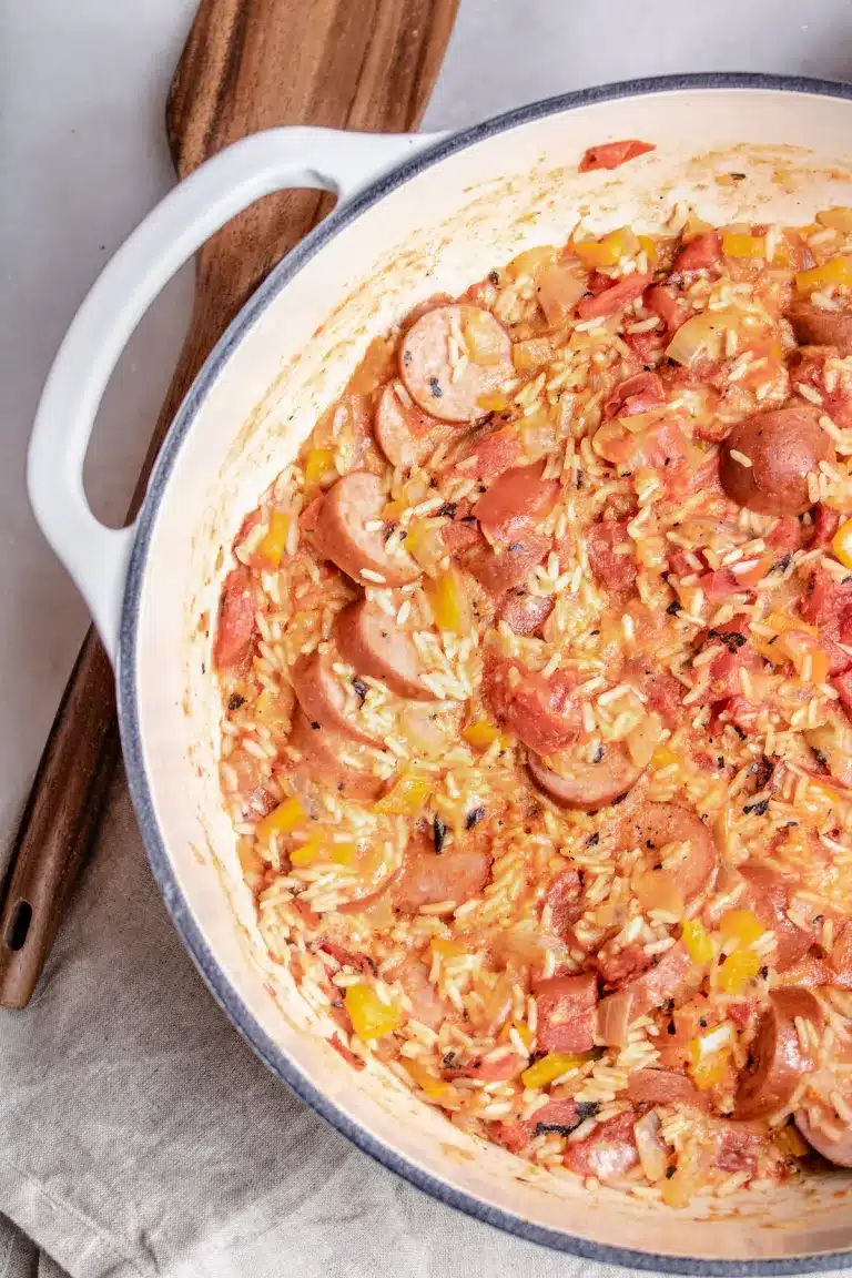 Jambalaya in a Dutch oven with wooden spoon in the background.