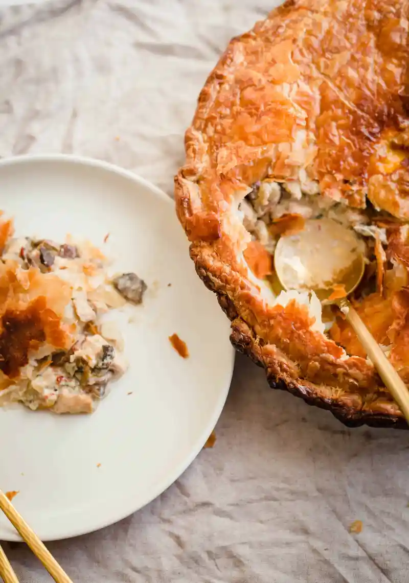 Indian chicken and mushroom pie served on a white plate with more to the side.