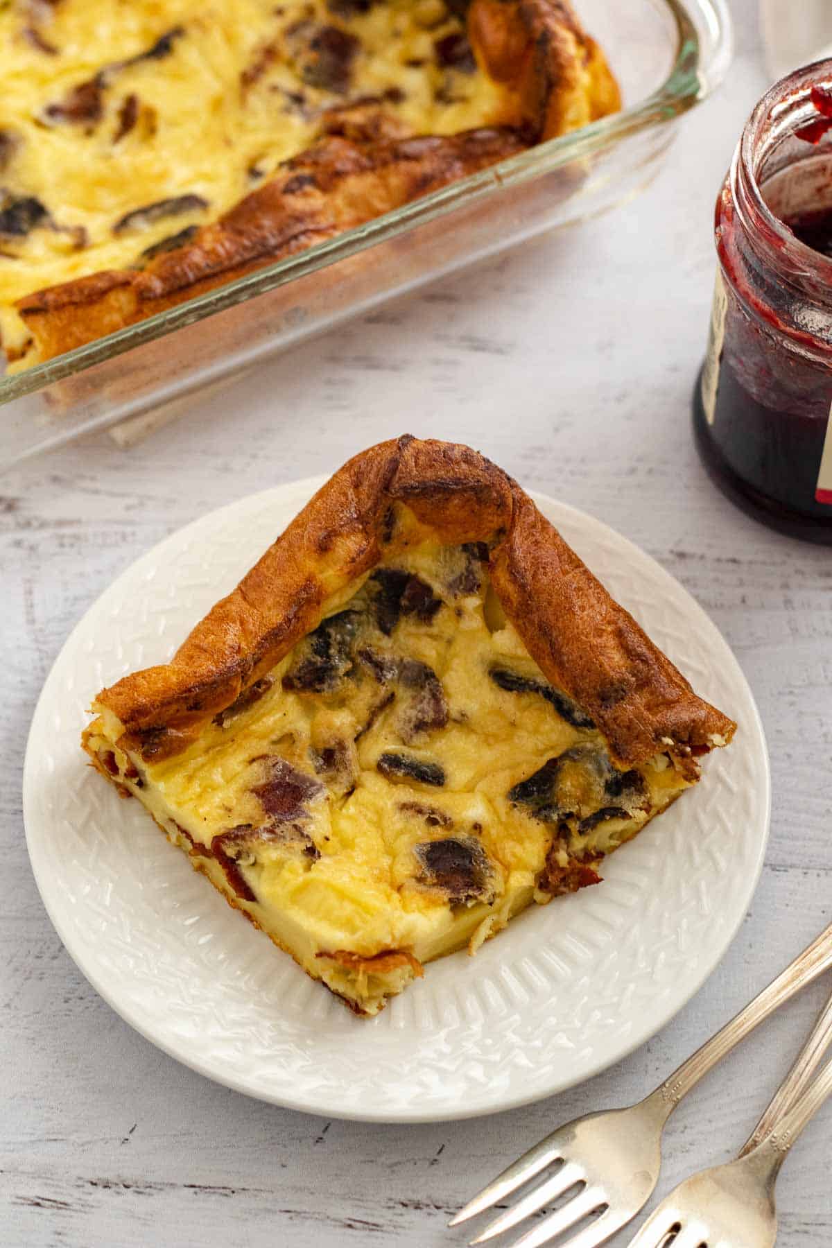 Swedish crunchy bacon pancake on a white plate with forks on the side.