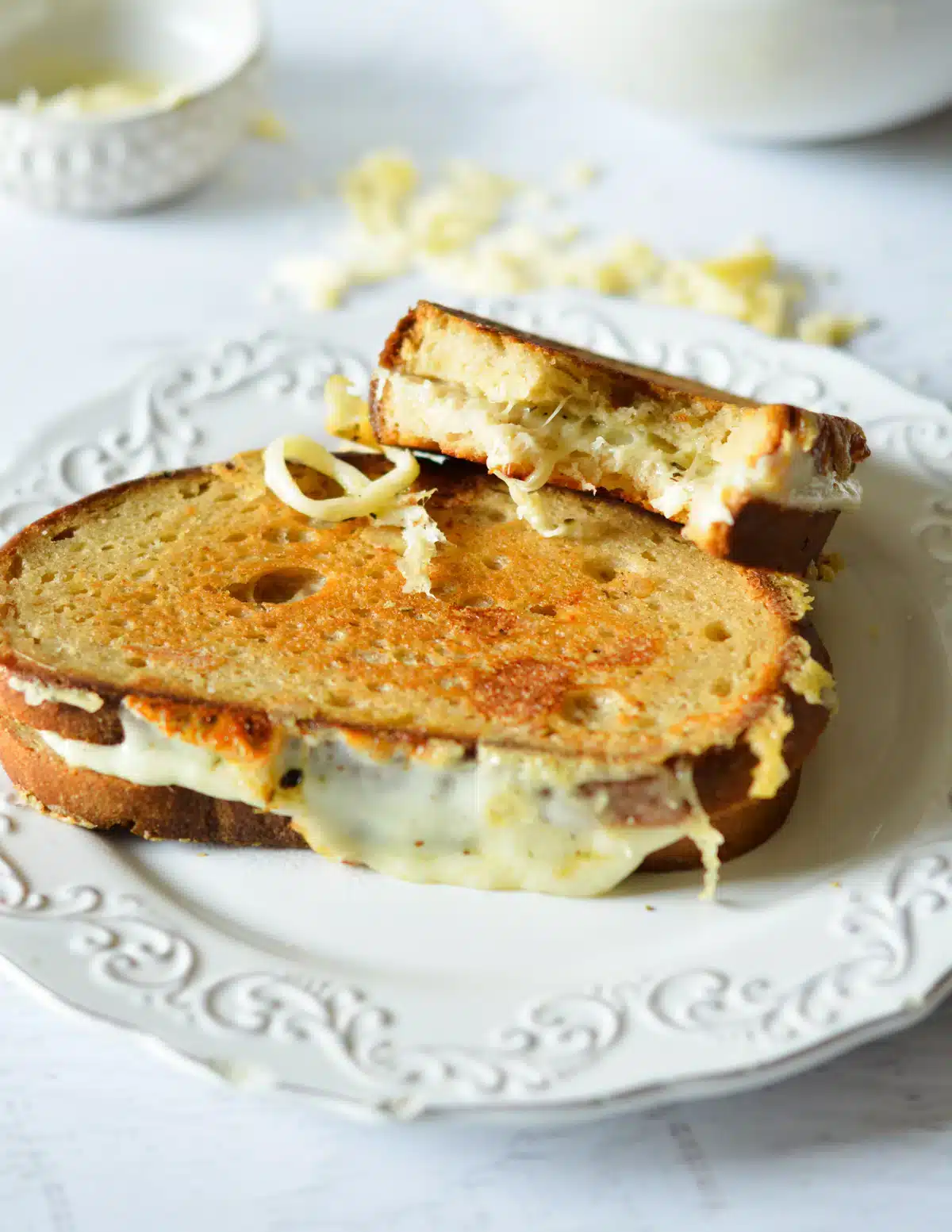 Grilled cheese sandwiches on a decorative white plate.