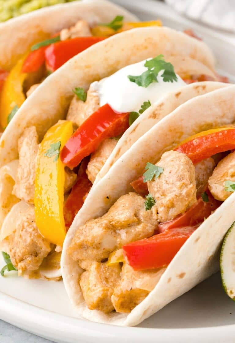 Closeup showing skillet ranch chicken fajitas on a white plate.