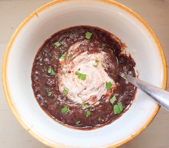 Slow cooker black bean soup in a white bowl.