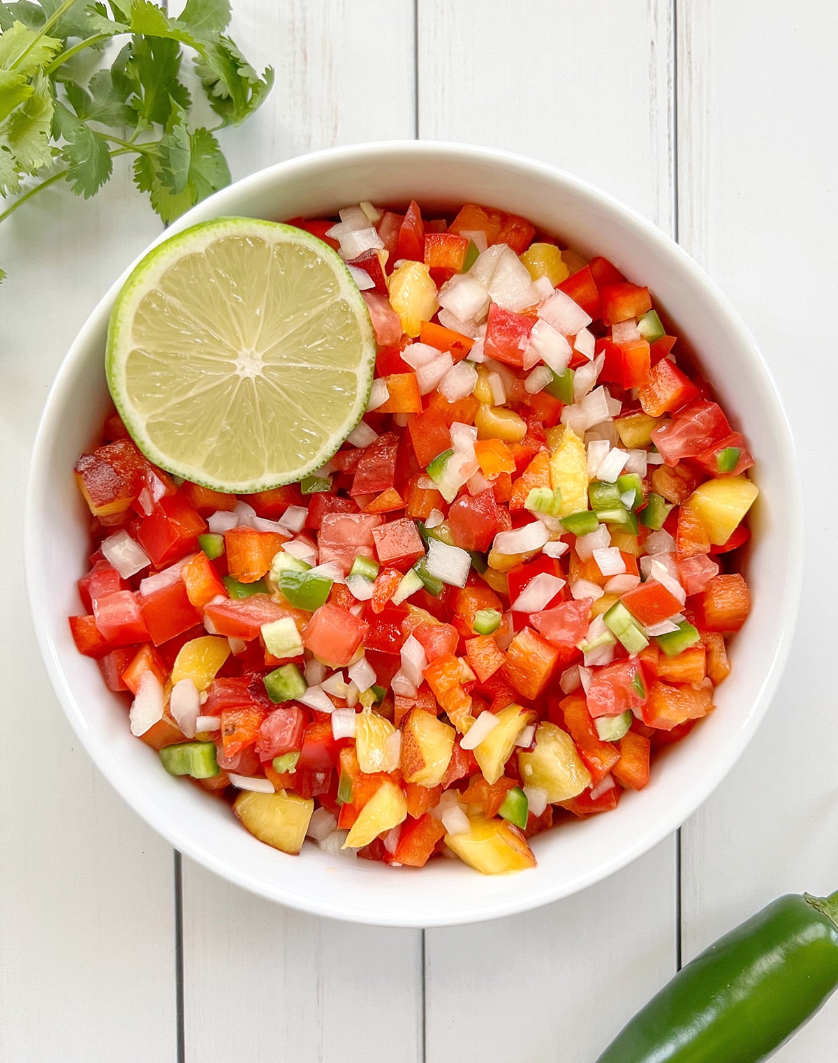 Spicy peach salsa in a white bowl.