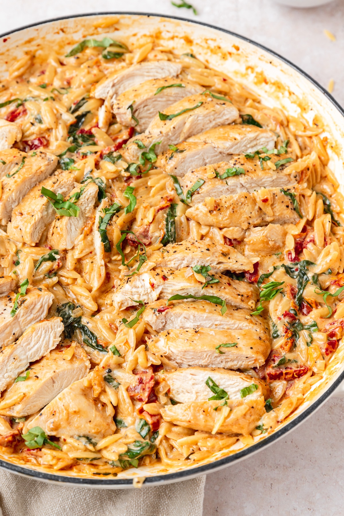 Pot full of creamy Tuscan chicken orzo.