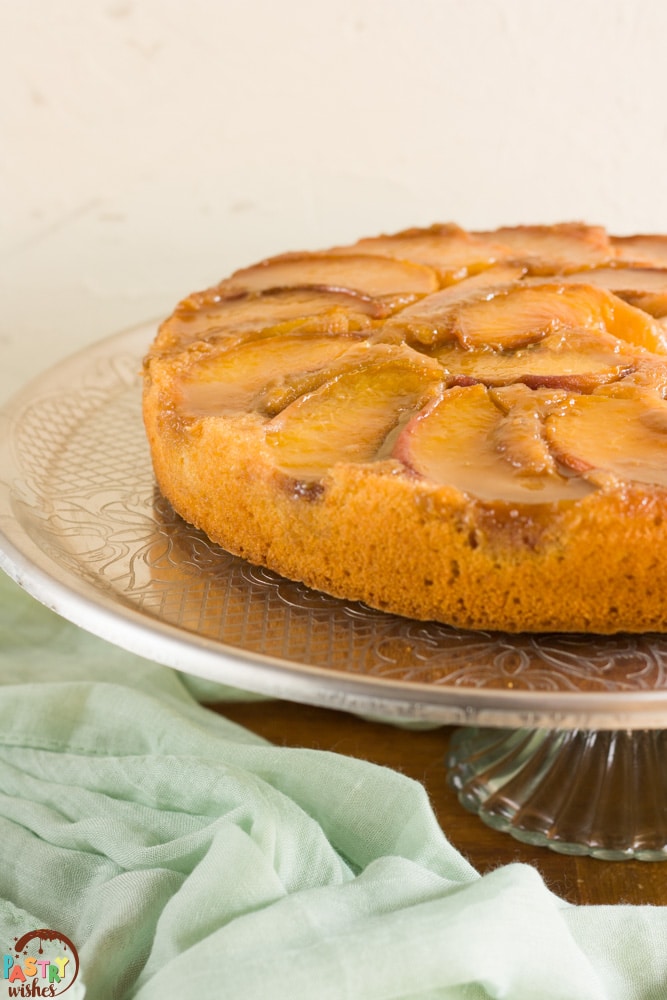 Peach upside down cake on a cake stand.