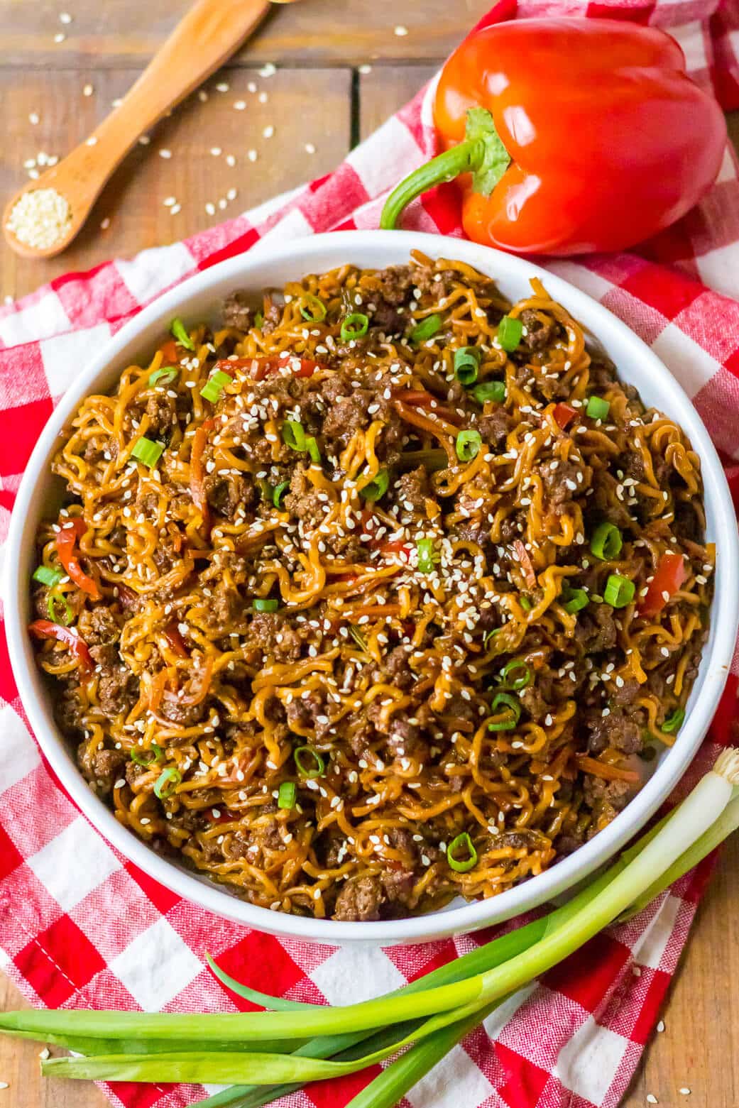 Beef ramen noodles in a white bowl with green onions.