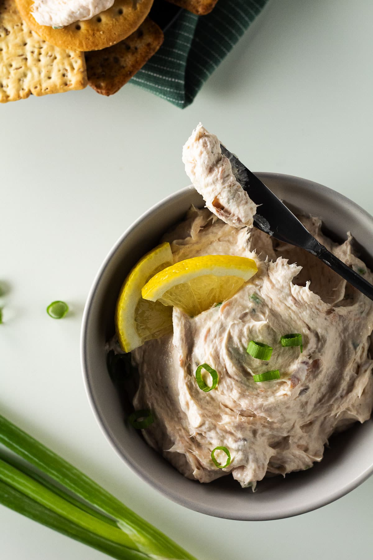 Bowl full of 5 ingredient smoked salmon dip with crackers in the background.