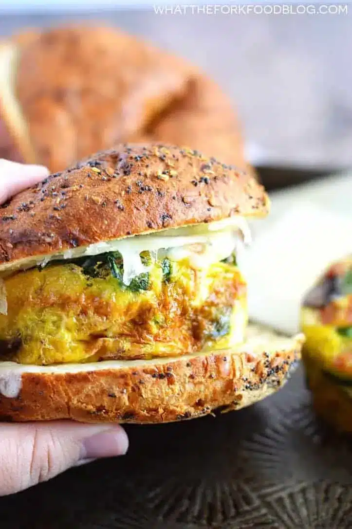 Hand holding frittata breakfast sandwiches.