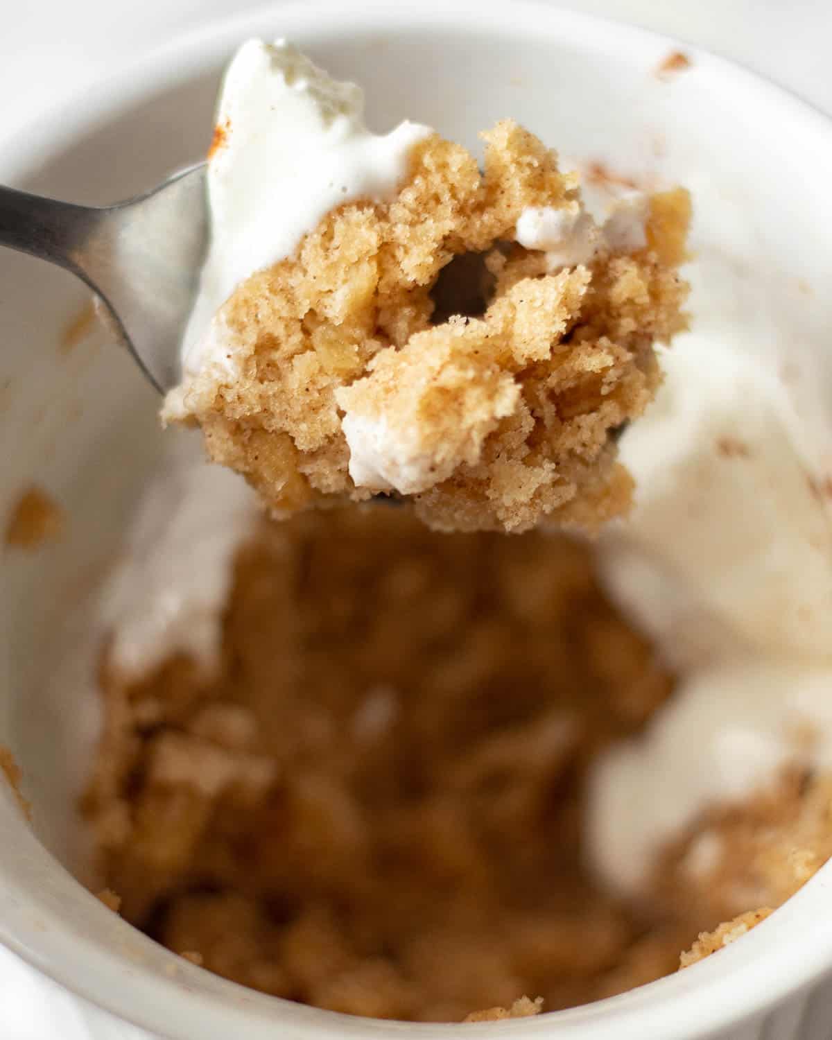 Spoon full of apple mug cake.