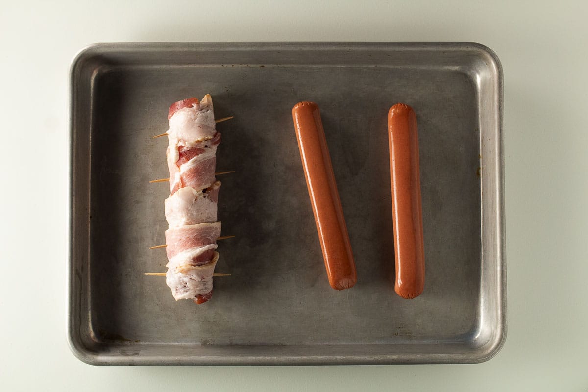 Hot dog stuffed with jalalpeno popper dip and wrapped in bacon.