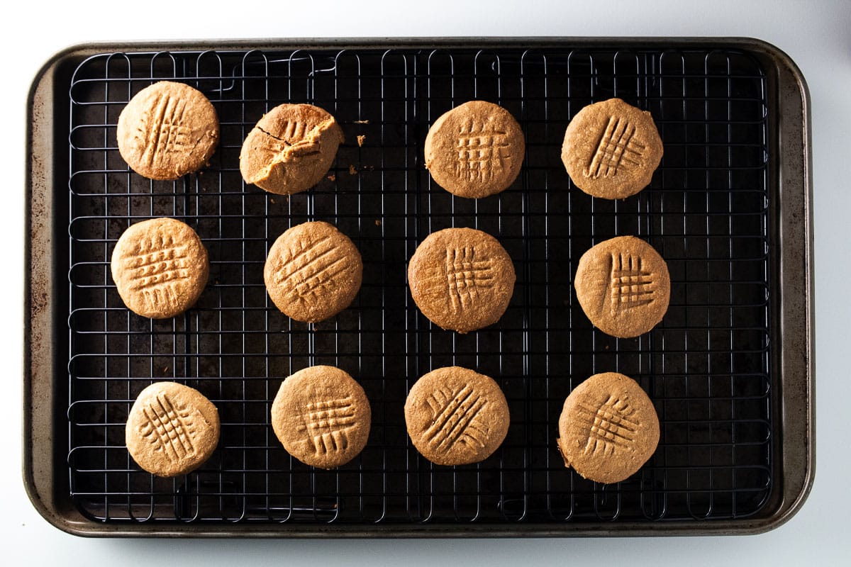 Peanut butter cookies on a black cooling rack.