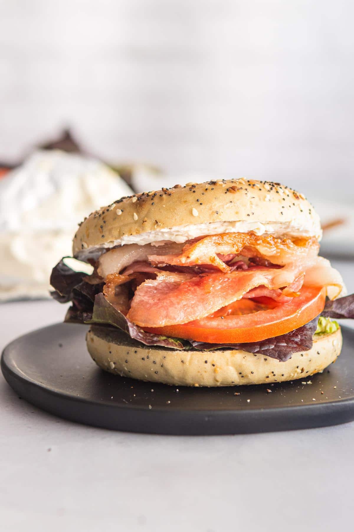 Bagel BLT on a dark plate.