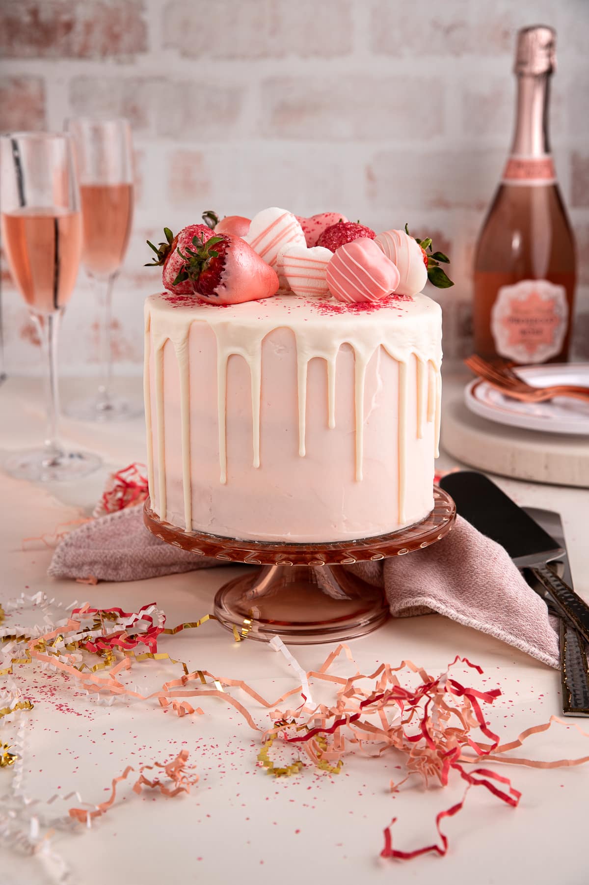 Gorgeous pink champagne cake on a cake stand.