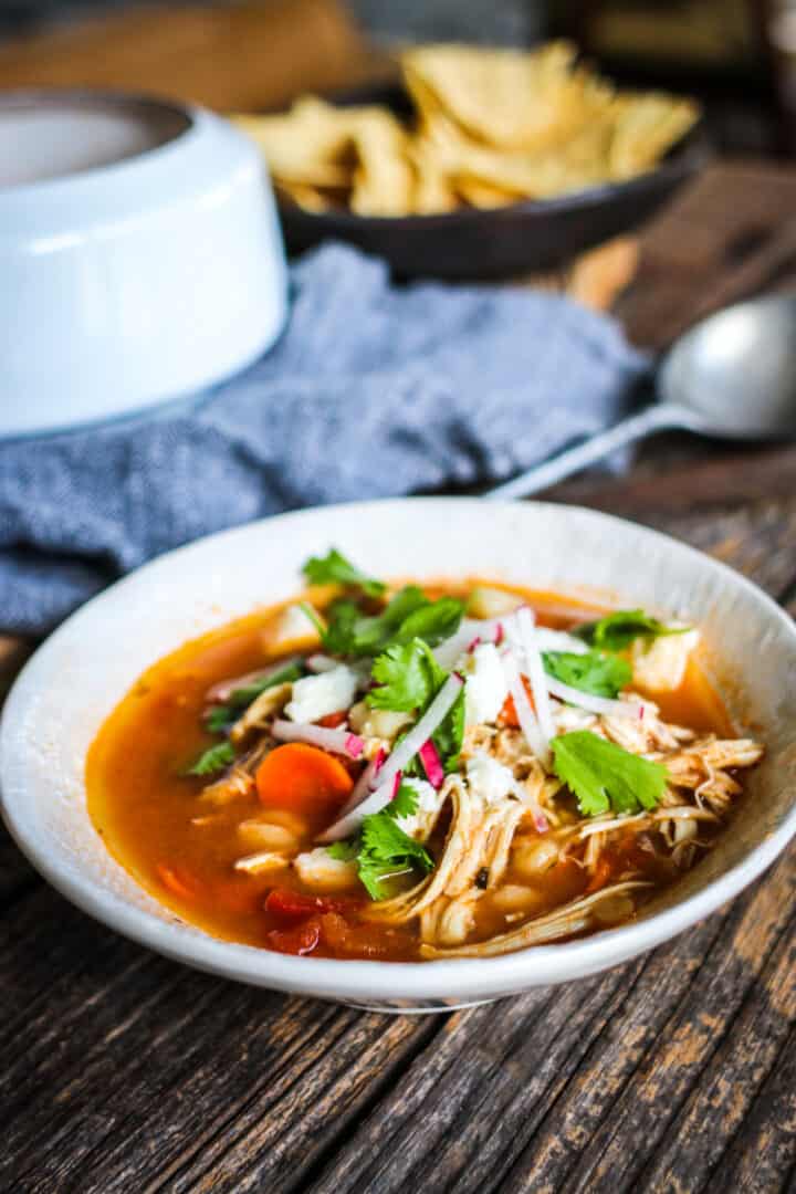 Chicken posole stew recipe in a grey bowl.