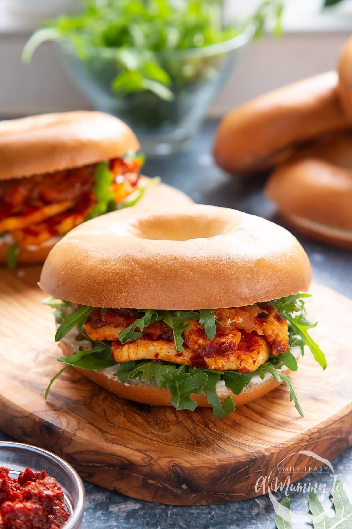 Halloumi bagel sandwich on a wooden board.