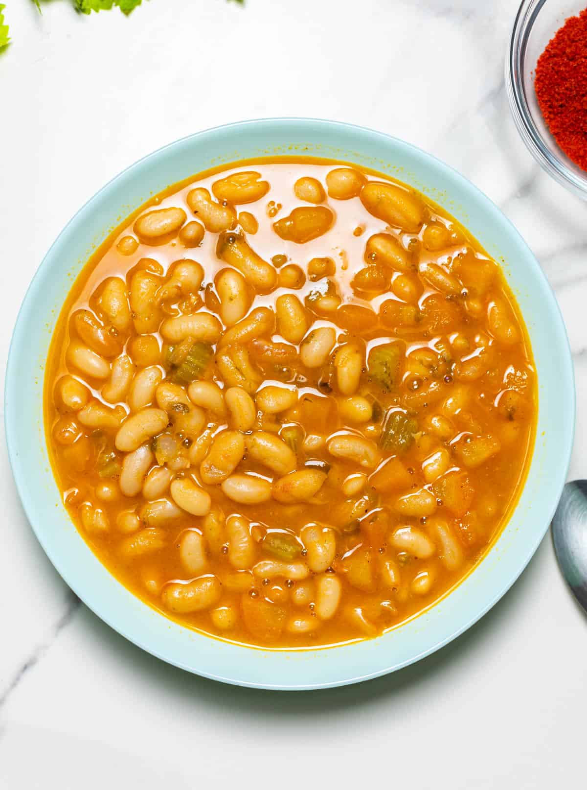 Navy bean soup in a light blue bowl.