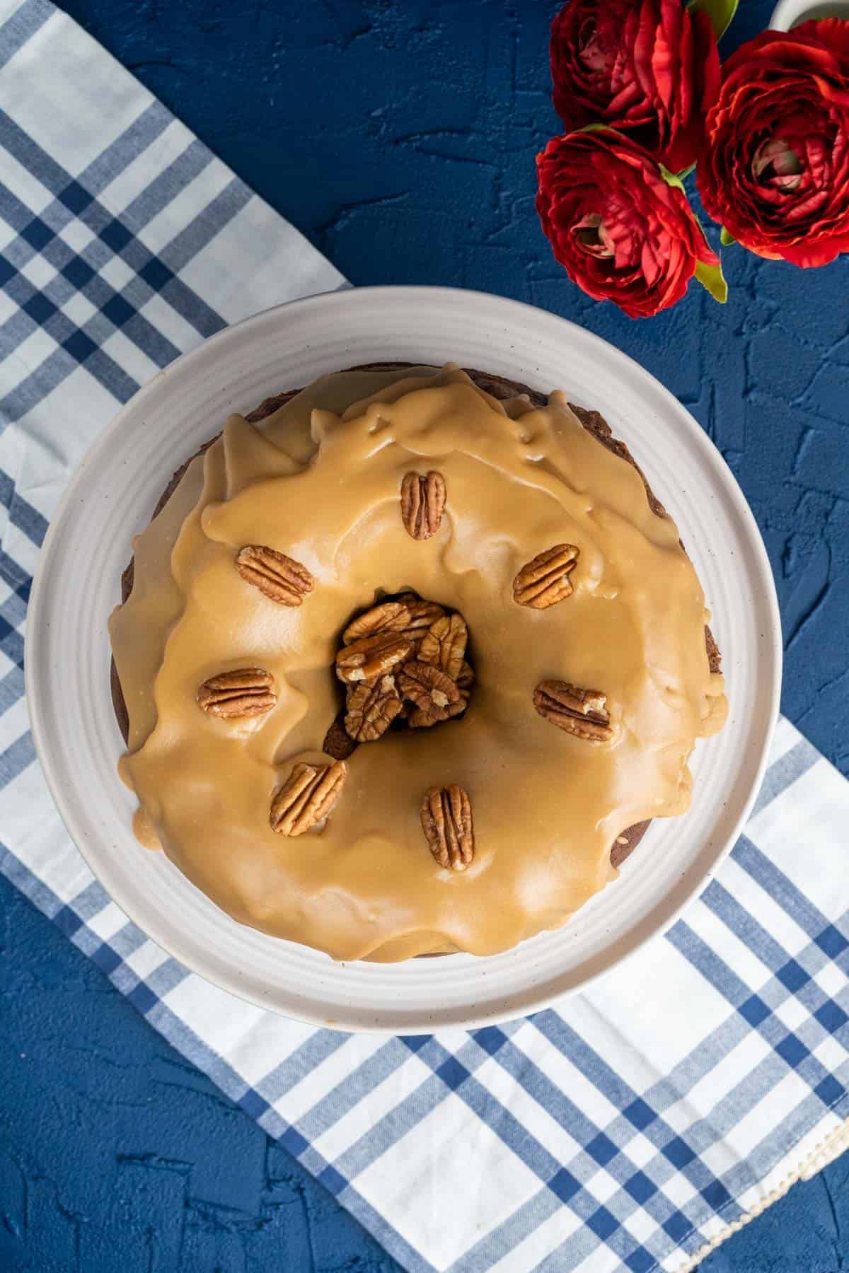 Pecan praline cake on a plate on a dark blue background.