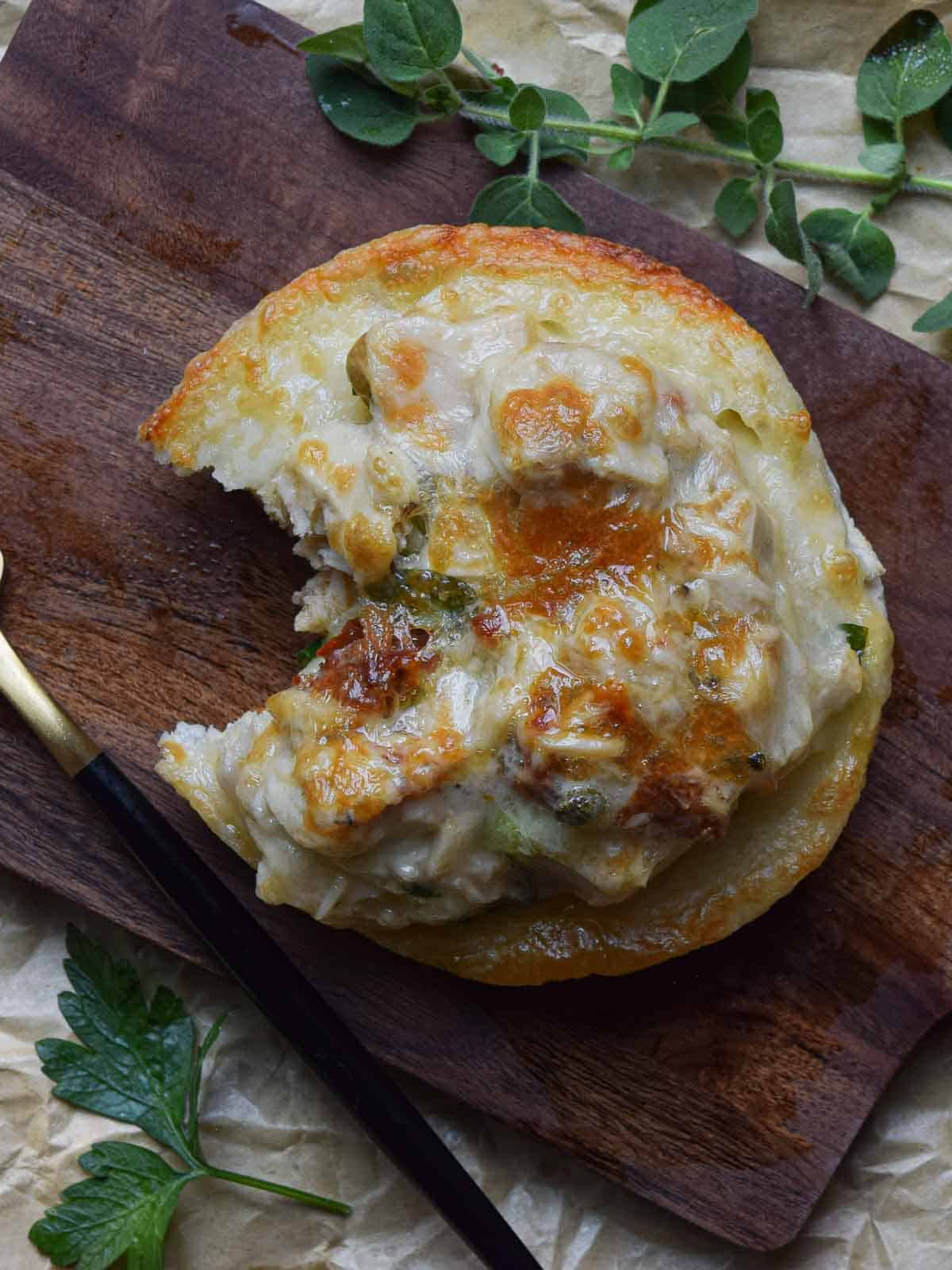 Sun-dried tomato tuna melt on a wooden board.