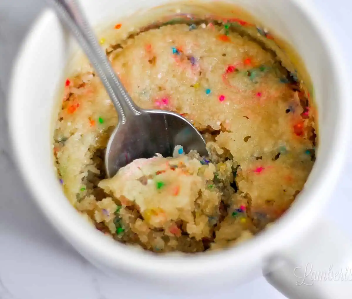 Confetti mug cake up close with a spoon.