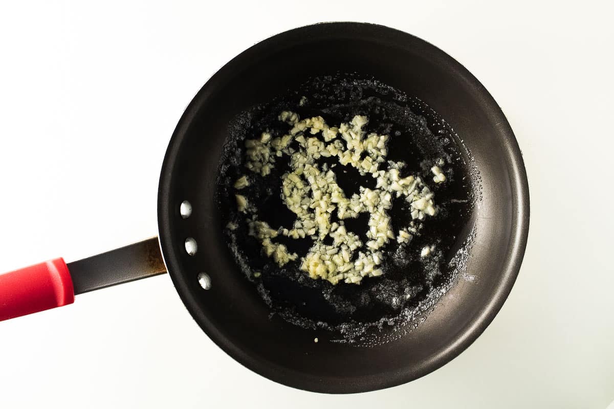 Melted butter with minced garlic in a skillet.