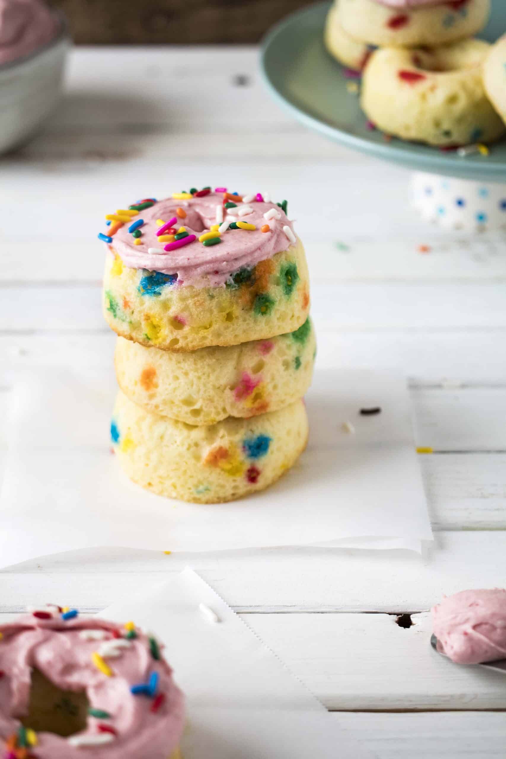 Stack of Funfetti colorful donuts with more in the background.