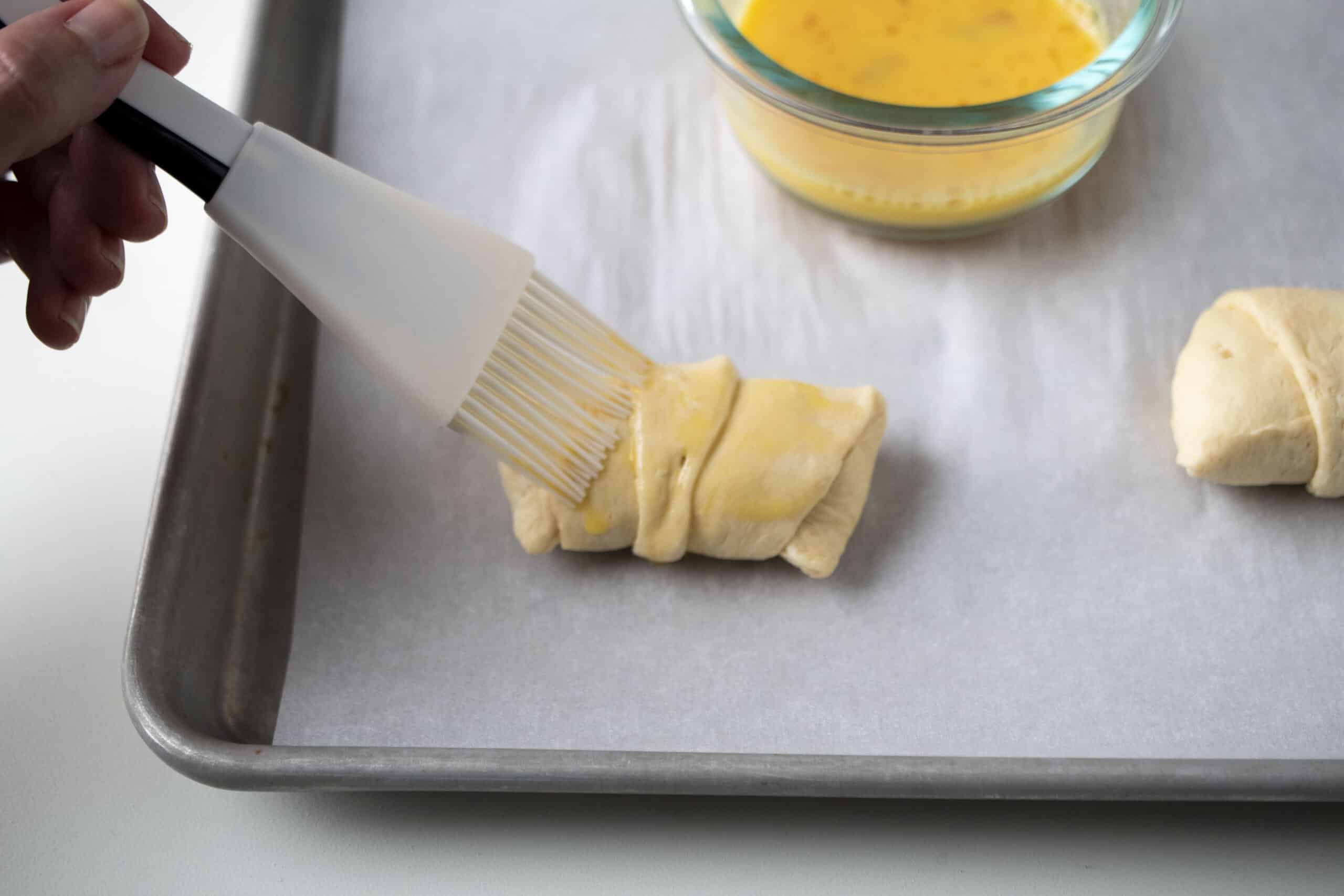 Brushing the chocolate cheesecake croissants with egg wash.