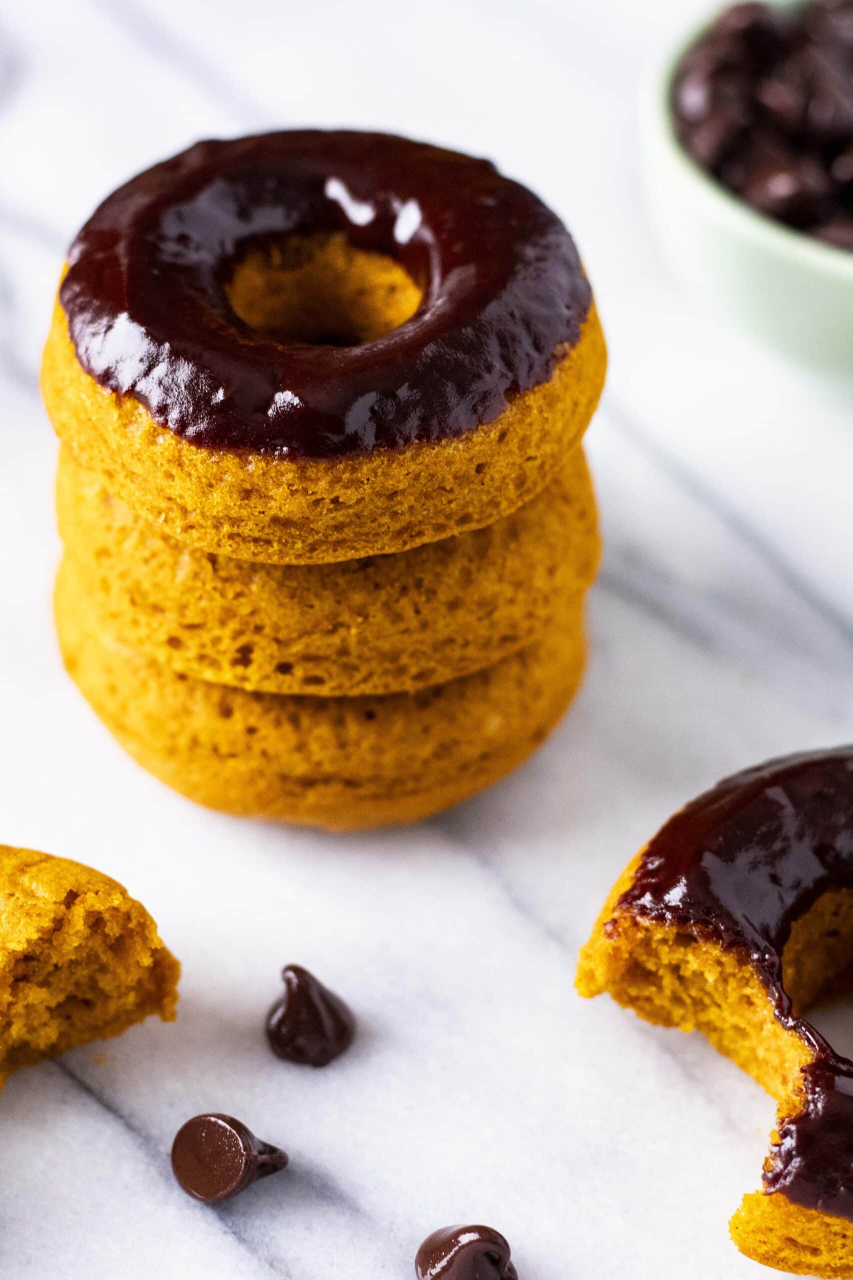 Stack of chocolate glazed pumpkin spice donuts.