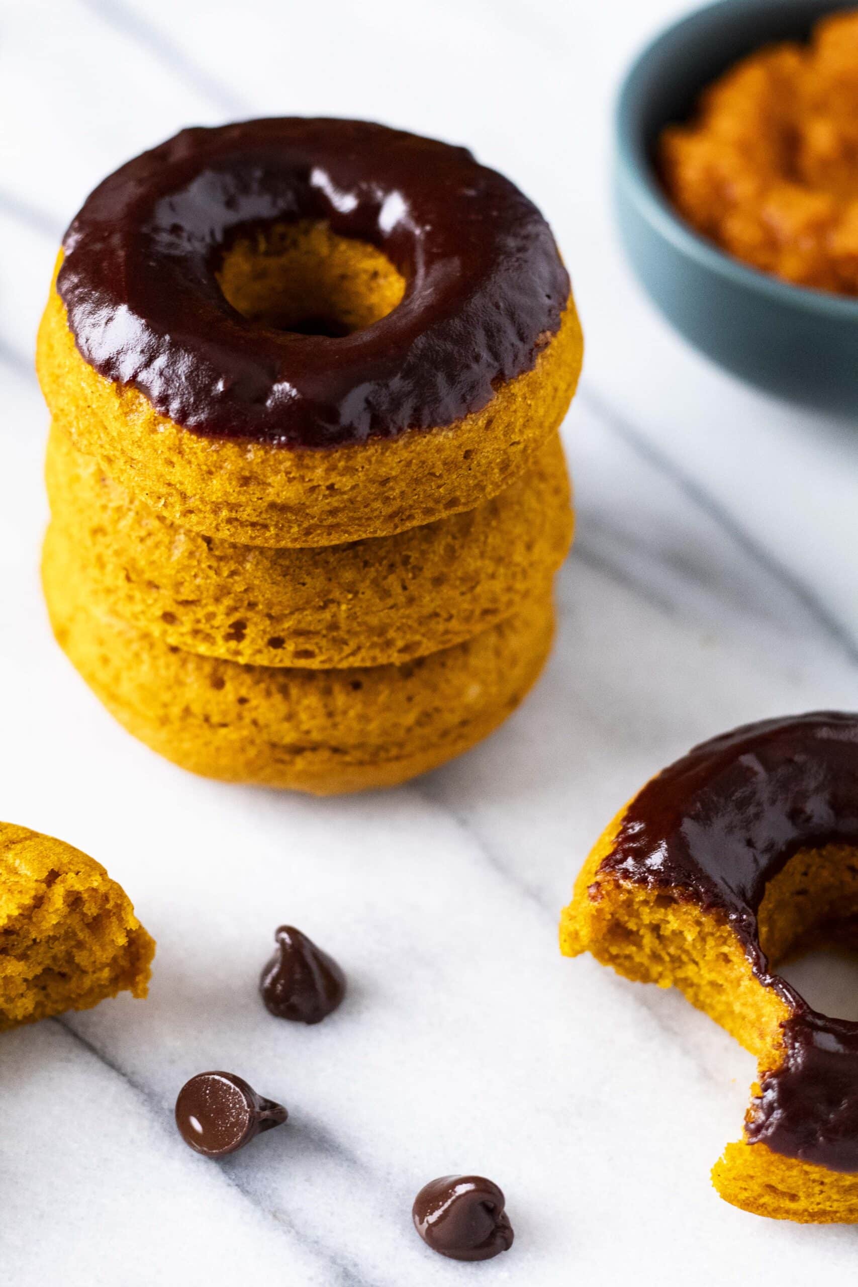 Stack of chocolate covered pumpkin spice donuts.