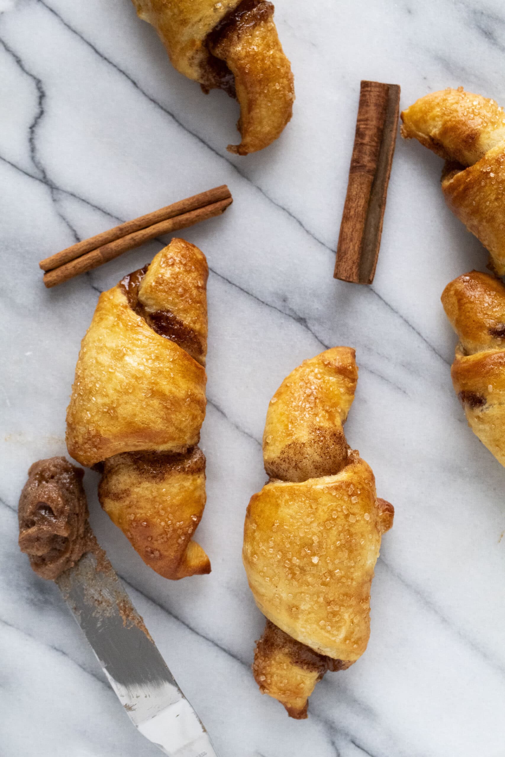 Air fryer cinnamon sugar croissants on a   marble surface.