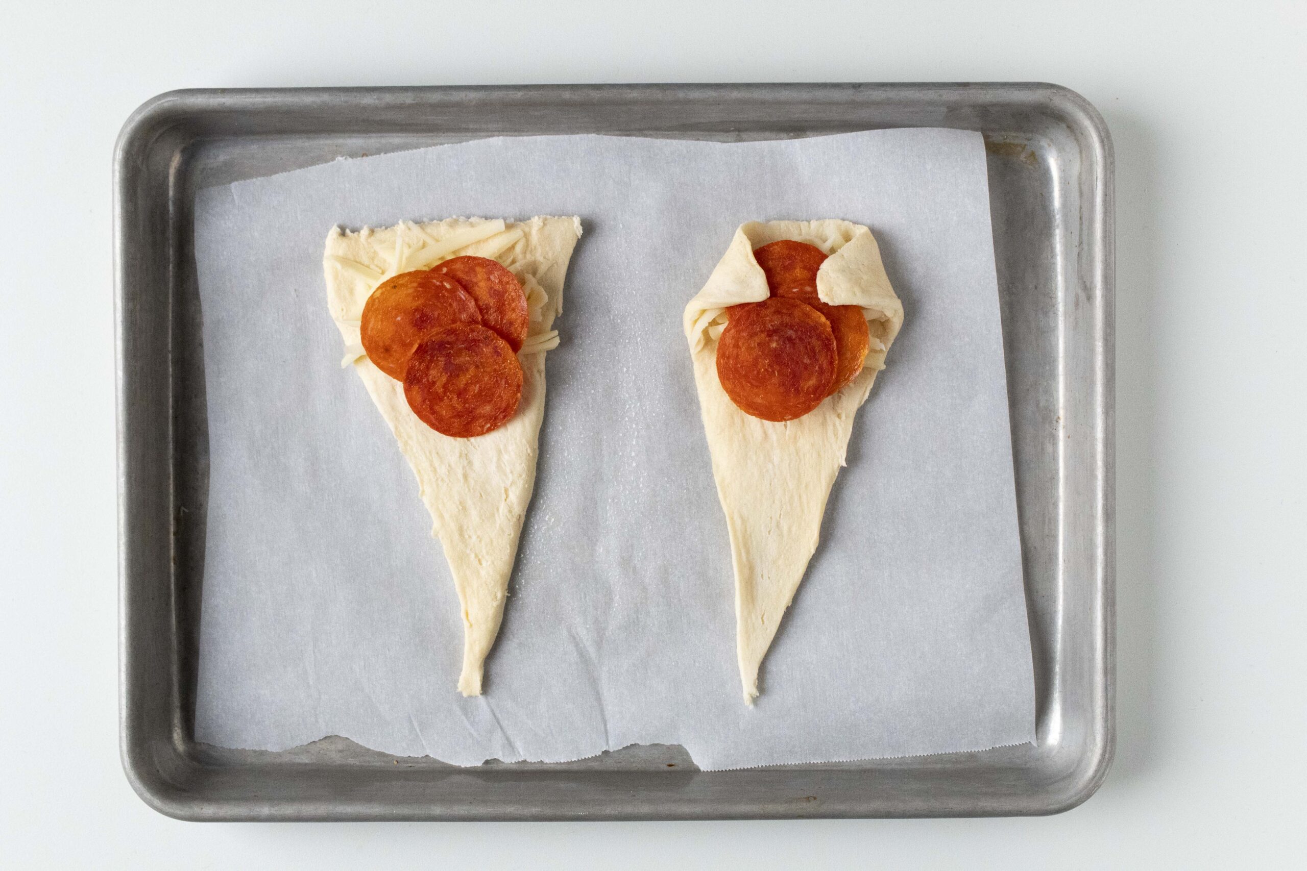 Folding pizza crescent rolls.