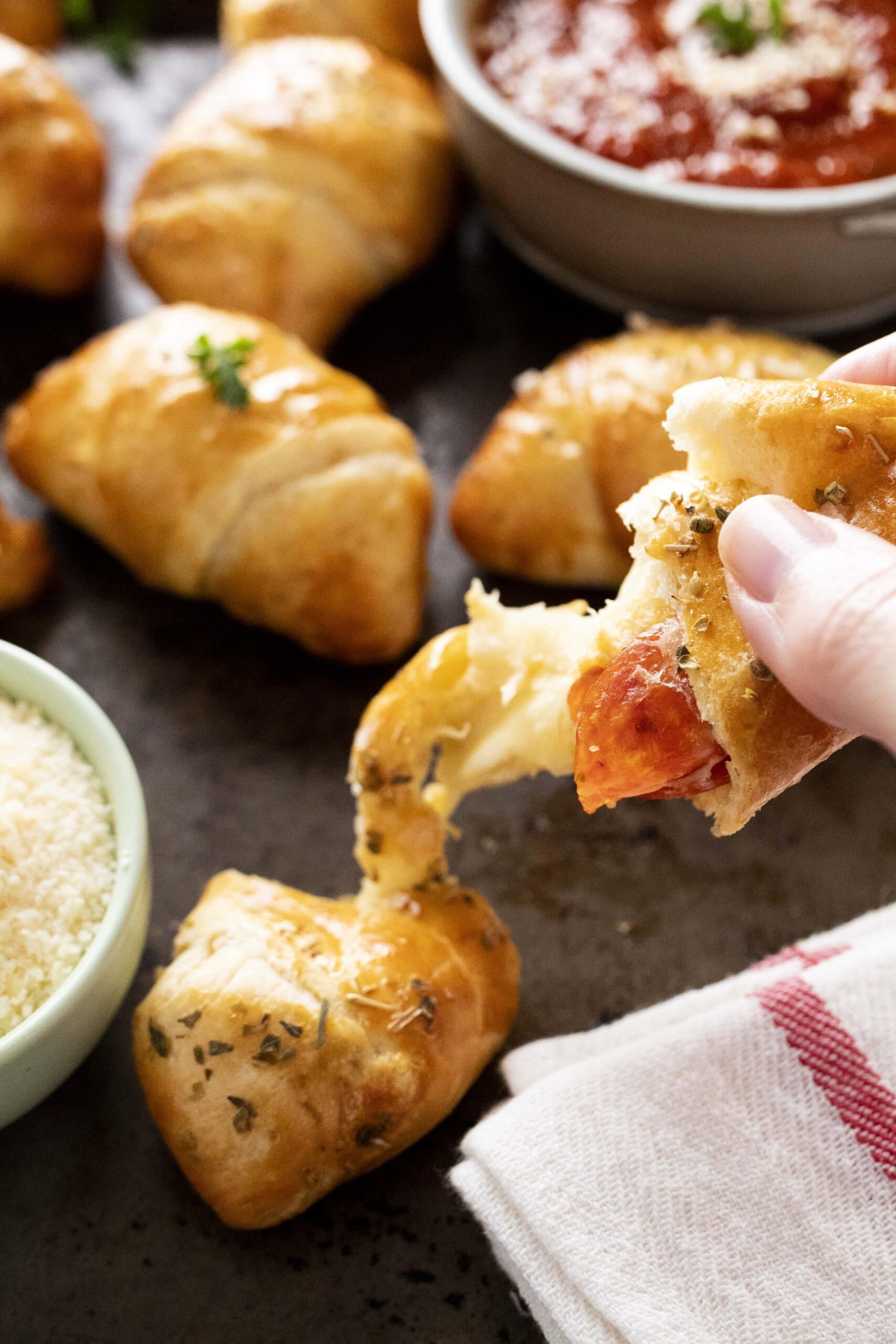 hand holding a piece of air fryer pizza crescent roll.