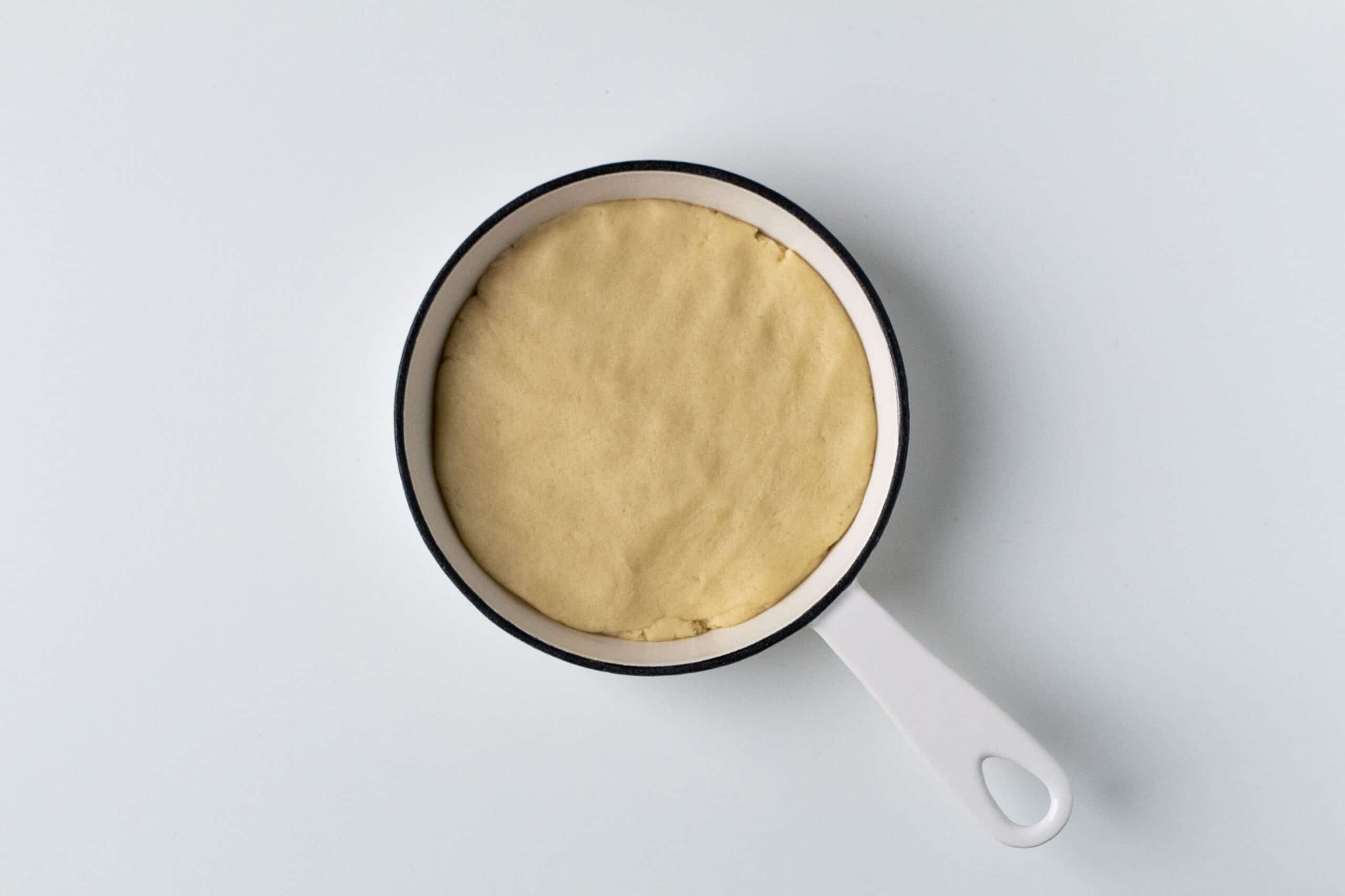 Sugar cookie dough in a small cast iron pan.