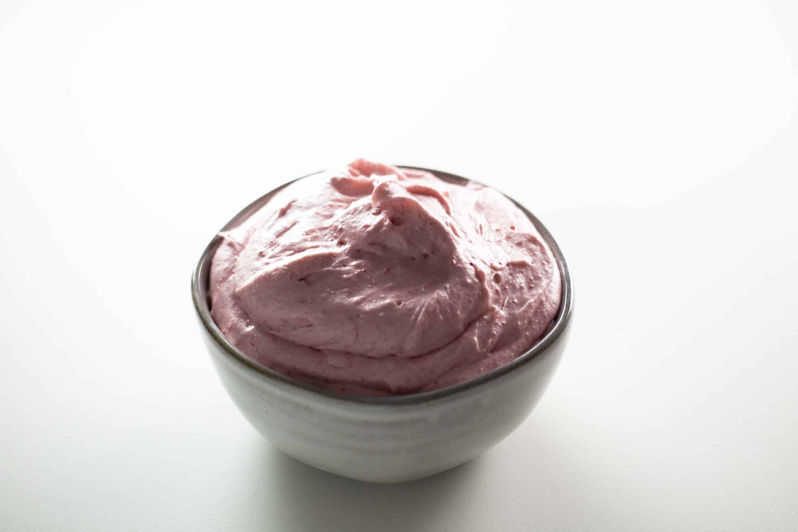 Bowl full of strawberry frosting.