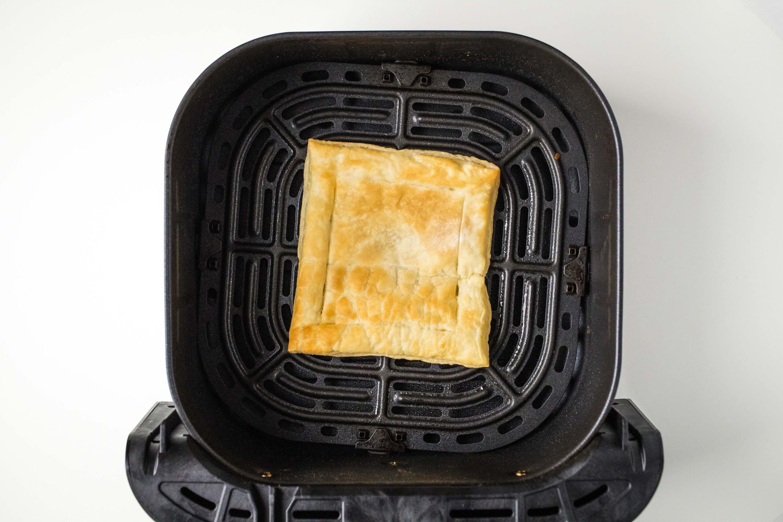 Cooked square of puff pastry in the air fryer.