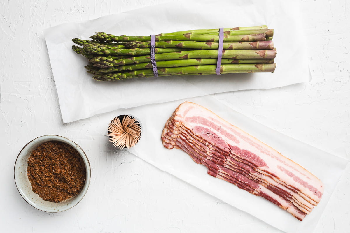 Overhead image showing ingredients to make bacon-wrapped asparagus.