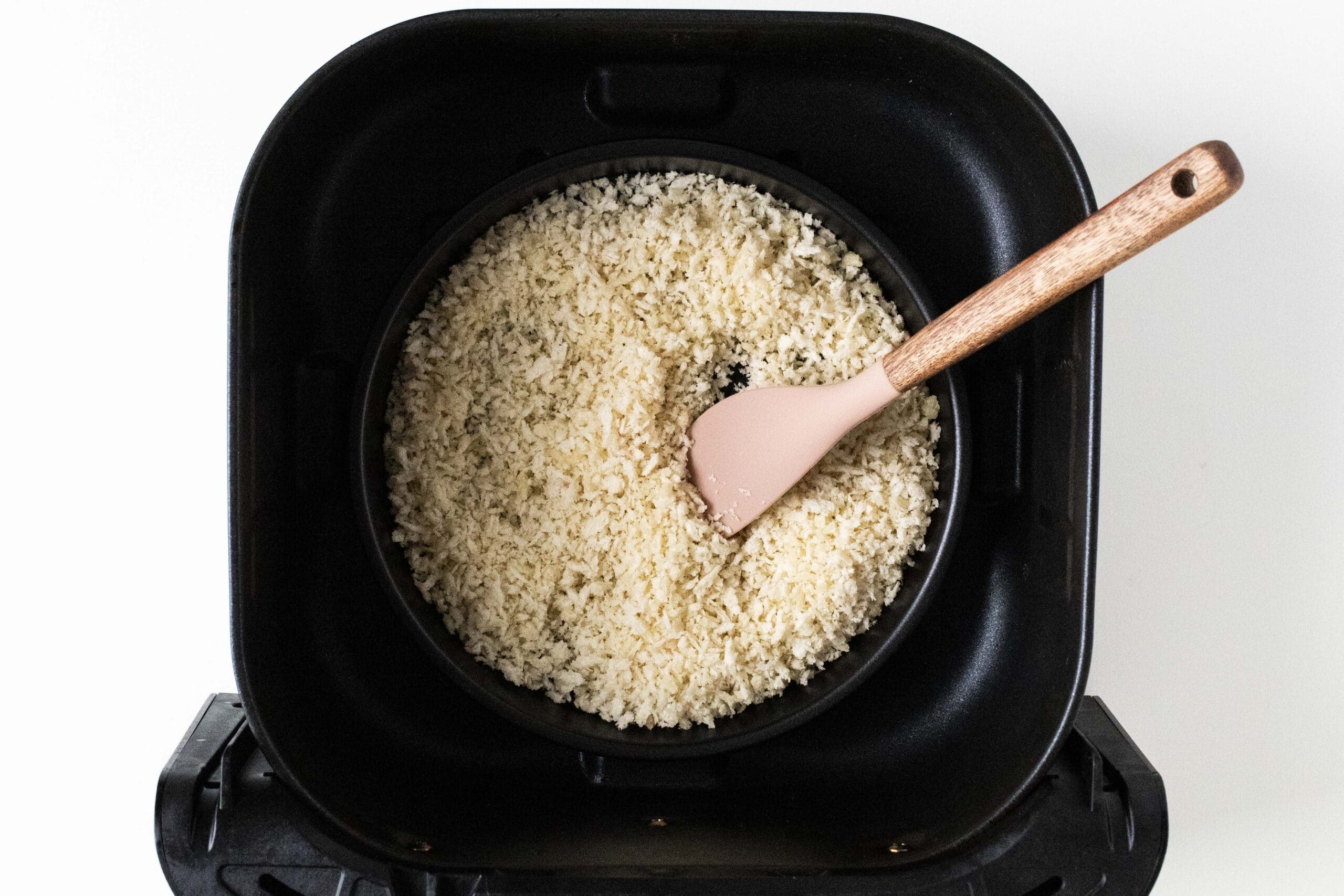 Panko breadcrumbs in a pan inside of air fryer basket.