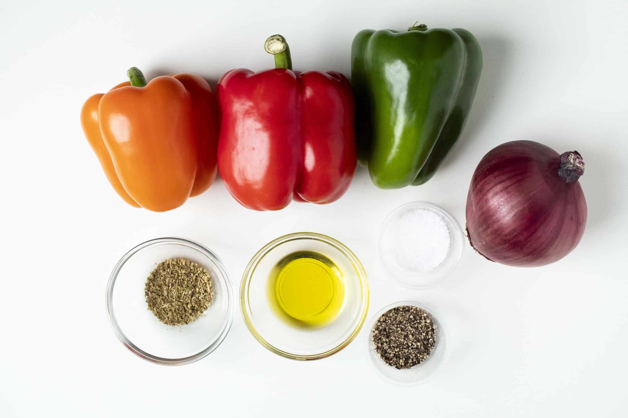 Ingredients for air fryer fajita vegetables including bell peppers, red onion, olive oil, oregano, salt, and pepper.