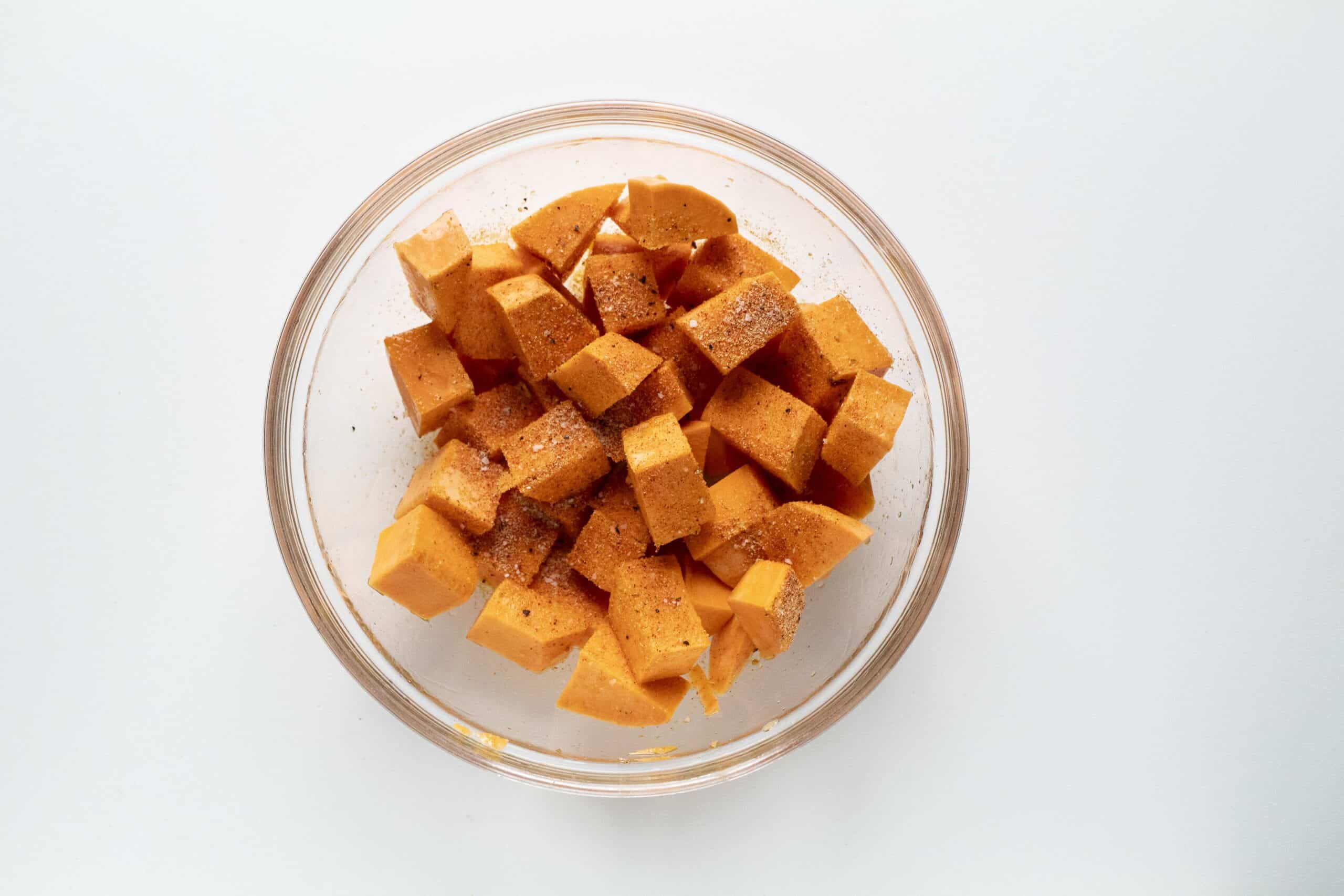 Diced and seasoned sweet potatoes in a bowl.
